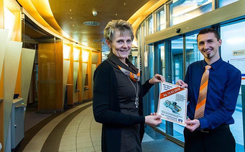 Ramona Hofmann und Jan Arndt zeigen ein Infoblatt, mit dem die Volksbank ihre Kunden auf die Umbauphase hinweist, die am Montag beginnt.