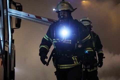 Ein Feuerwehrmann mit Atemschutz blickt in die Kamera des Fotografen. (FOTO: DPA)