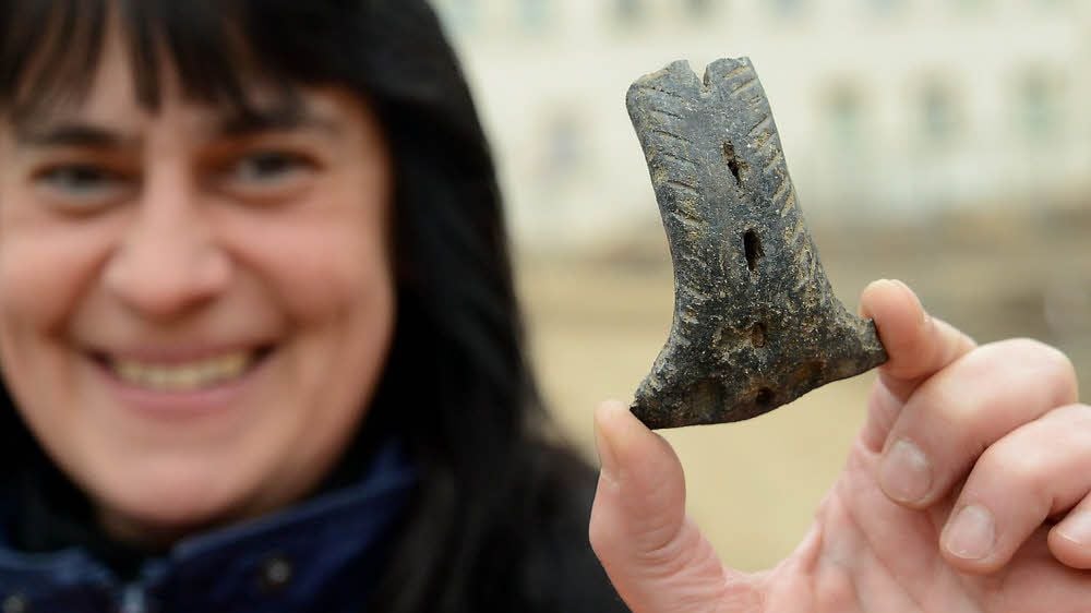 Grabungshelferin Jacqueline Küster zeigt eine sehr schöne Keramik, den Teil eines Henkels einer Bügelkanne aus dem 13. Jahrhundert.
