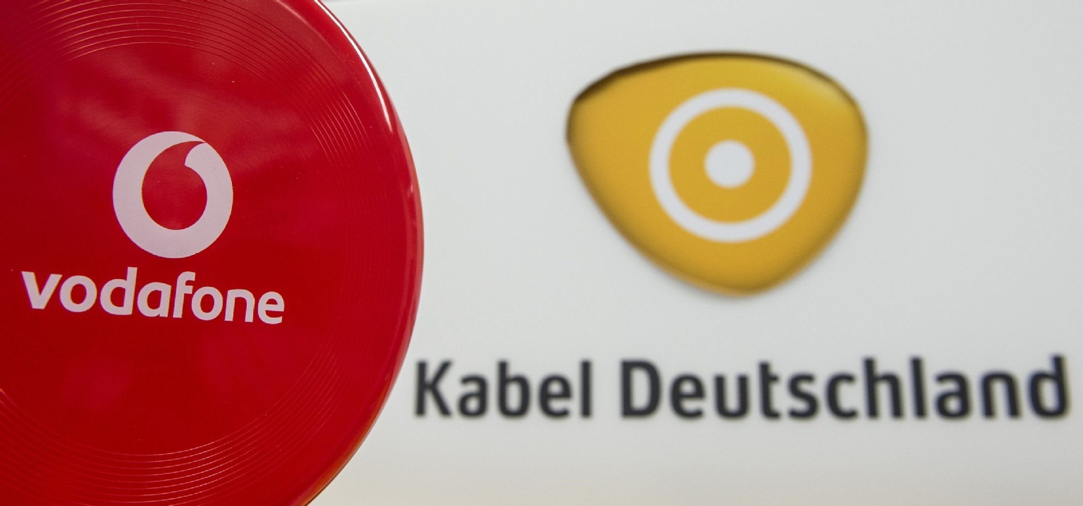 Das Logo des Mobilfunkanbieters Vodafone (l) neben dem Schriftzug des Kabelnetzbetreibers Kabel Deutschland