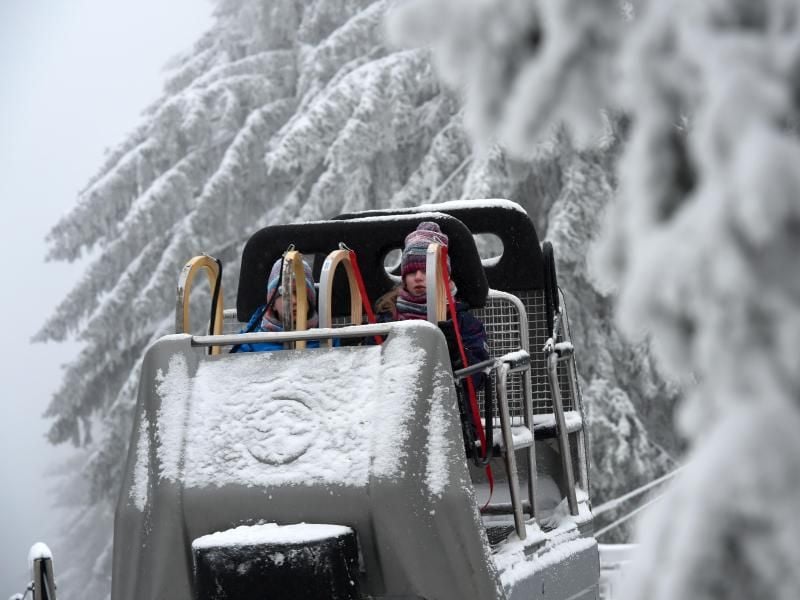 Rodler sitzen auf der Wasserkuppe im Lift. Foto: Uwe Zucchi/dpa/Archiv