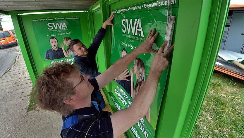 Steffen Apelt (vorn) und Maik Hartmann bringen das Plakat an.