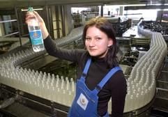 In der Margon Brunnen GmbH im sächsischen Burkhardswalde präsentiert wenige Tage vor dem 100. Jahrestag des Unternehmens Manuela Nagy vor der Abfüllanlage eine Flasche der Sorte Medium. (Foto: dpa)