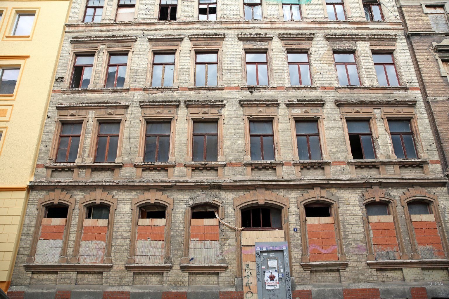 Ein leerstehendes Haus mit teilweise zugemauerten Fenstern.