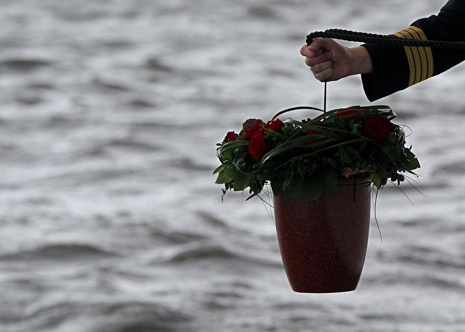 Ein Seebestatter lässt in Höhe der ostfriesischen Insel Wangerooge eine Urne aus Muschelkalk in die Nordsee hinab.