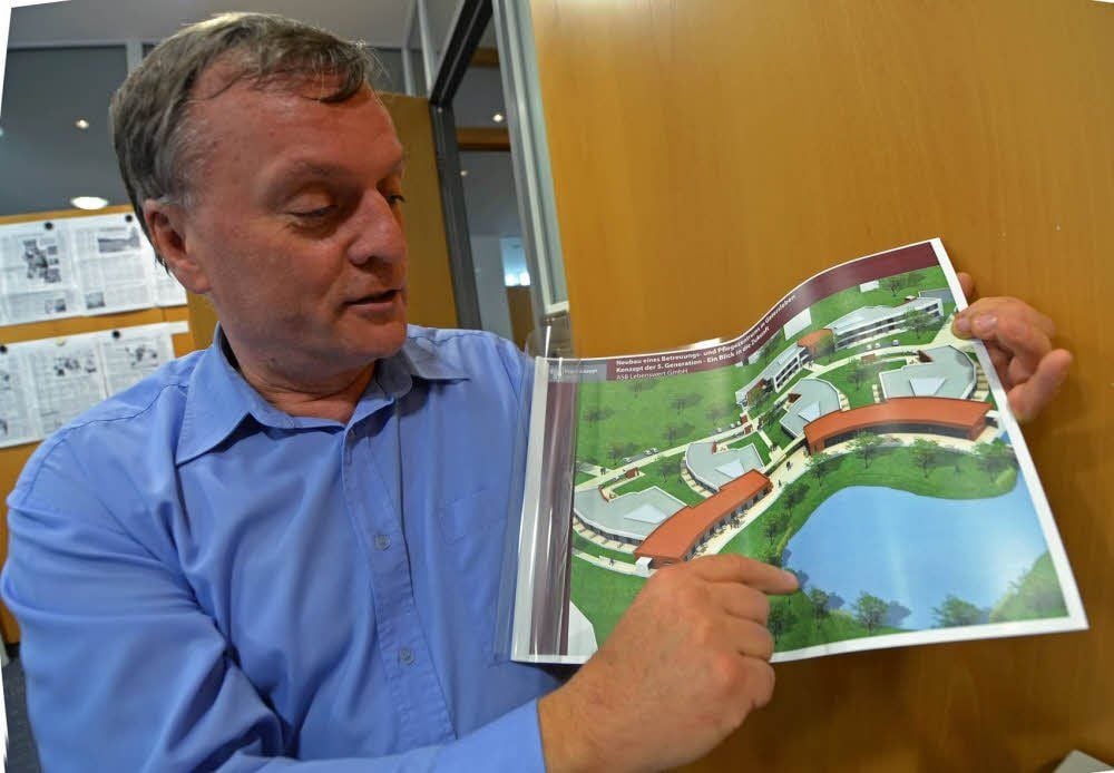 Christoph Köppe, der für das Projekt verantwortlich ist, zeigt erste Pläne von dem Pflegezentrum.