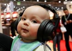 Der kleine Lasse lauscht über große Kopfhörer auf seinem kleinen Kopf einer Hörbuch-CD auf der Leipziger Buchmesse 2007. (Foto: dpa)