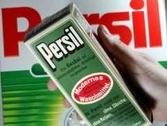 Eine historische Packung des Waschpulvers «Persil» hält in Düsseldorf eine junge Frau vor ein aktuelles Packet. (Foto: dpa)
