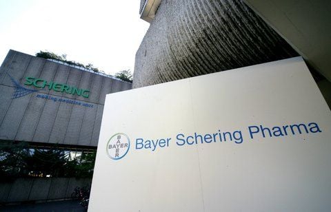 Das Logo der Bayer Schering Pharma AG (r.) und vor einem Gebäude der Schering AG vor dem Zusammenschluss im Jahr 2006. (FOTO: DPA/ARCHIV)