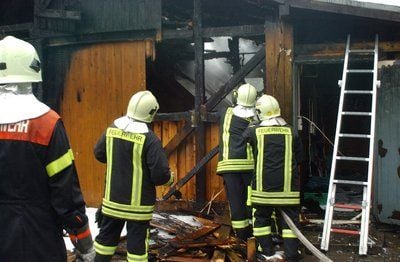 Feuerwehrleute löschen in der Kinder- und Jugendfarm in Hoyerswerda. Pferde, Ponys und Esel entkamen den Flammen nicht. (FOTO: DPA)