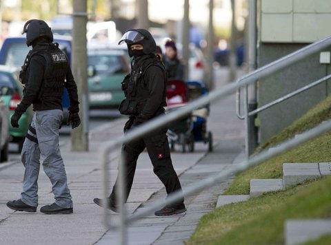 Polizisten in Schutzkleidung verlassen das Haus in Bad Langensalza, in dem sich der Vater mit seinem Sohn verschanzt hatte. (FOTO: DAPD)