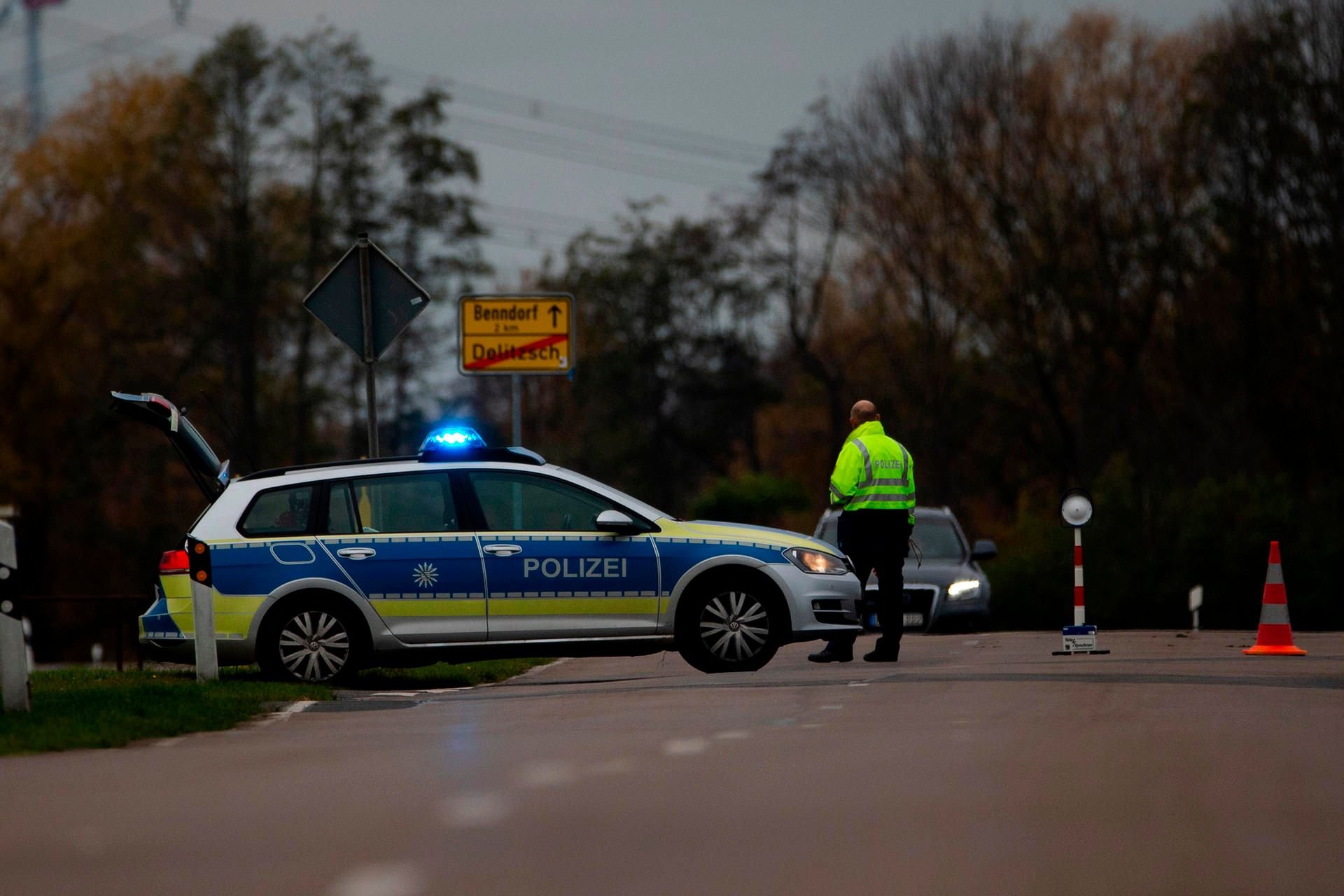 Delitzsch: Ein Polizist riegelt die Zufahrt zu einer Wohnsiedlung in Delitzsch ab.