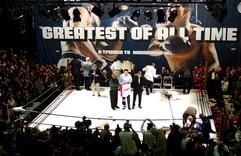 Der schwer an Parkinson erkrankte Muhammad Ali (M.) präsentiert am Donnerstag (09.10.2003) auf der Frankfurter Buchmesse in einem eigens für seinen Besuch errichteten Boxring das Monumental-Buch "Greatest of all time" (GOAT). Das Werk kostet 7500 Euro, wiegt mehr als 30 Kilogramm und ist im Taschen-Verlag erschienen. (Foto: dpa)
