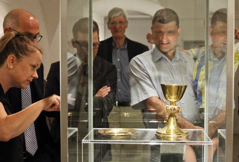Staunend betrachten Ausstellungsbesucher den goldenen Kelch, eine Leihgabe aus Stockholm.