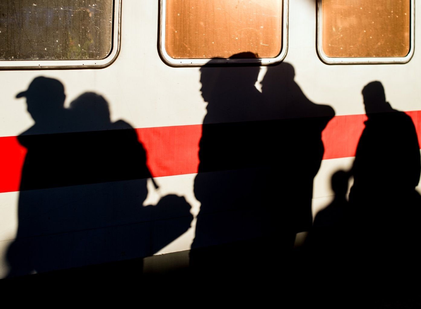 Flüchtlinge laufen nach ihrer Ankunft über einen Bahnsteig.