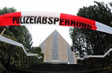 Ein Absperrband der Polizei hängt vor der Kirche «Heilige Familie» in Braunlage (Niedersachsen). Eine 48-jährige Küsterin war am Sonnabend tot im Keller der katholischen Kirche entdeckt worden. (FOTO: DPA)