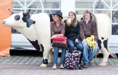Die Kirchentagsgäste Claudia (v.l.), Katharina und Rene machen auf dem 32. Evangelischen Kirchentag in Bremen eine Pause, während sie auf einer Kuhattrappe sitzen. «Mensch, wo bist du?» lautet das Motto des Kirchentages, der vom 20. bis 24. Mai 2009 in der Hansestadt stattfindet. (FOTO: DPA)