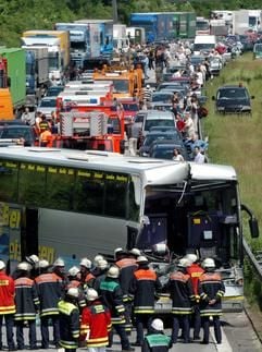 Feuerwehrleute stehen vor dem an der Frontseite total zerstörten Bus nach einem Unfall auf der A 7 in Hamburg. (Foto: dpa)
