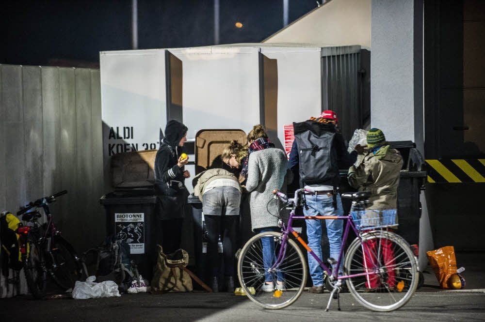 Junge Leute durchsuchen nachts die Mülltonnen eines halleschen Supermarkts. Die sogenannte Containerer-Szene ist in Halle sehr aktiv.