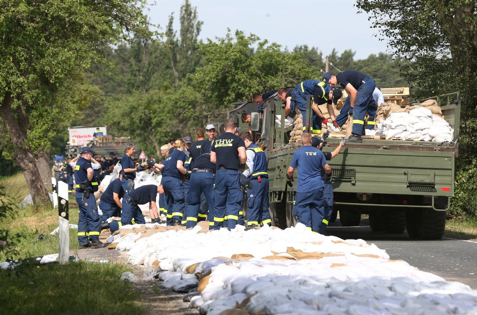 Hilfskräfte des THW schichten am 13. Juni einen Hilfsdamm aus Sandsäcken auf einer Landstraße zwischen Wulkau (Sachsen-Anhalt) und dem Nachbarort Kamern auf.
