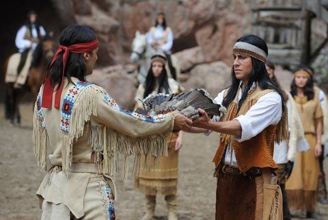Die Schauspieler Erol Sander als Winnetou (l) überreicht Philip Schwarz als Shi-So den Federschmuck des Häuptlings während einer Präsentation des Abenteuers «Der Ölprinz» bei den Karl-May-Spielen in Bad Segeberg. (FOTO: DPA)