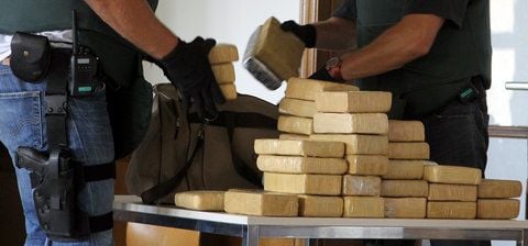 Zollbeamte in schusssicheren Westen breiten zu Beginn einer Pressekonferenz in Berlin sichergestelltes Kokain auf einem Tisch aus. (FOTO: DPA)