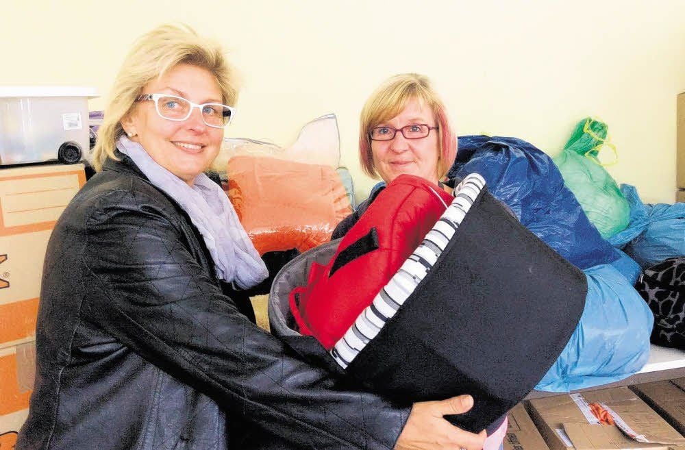 Kerstin Hertwig (l.), stellvertretende Betriebsratsvorsitzende der Total, übergibt Andrea Felsch vom Dienstleistungscentrum der gemeinnützigen Works gGmbH zum Beispiel eine Tragetasche für einen Kinderwagen.