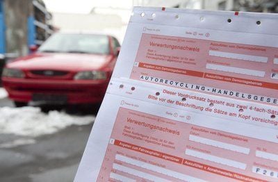 Ein Verwertungsnachweis ist auf dem Hof eines Autoverwerters in Frankfurt am Main neben einem Altfahrzeug zu sehen. (FOTO: DPA)