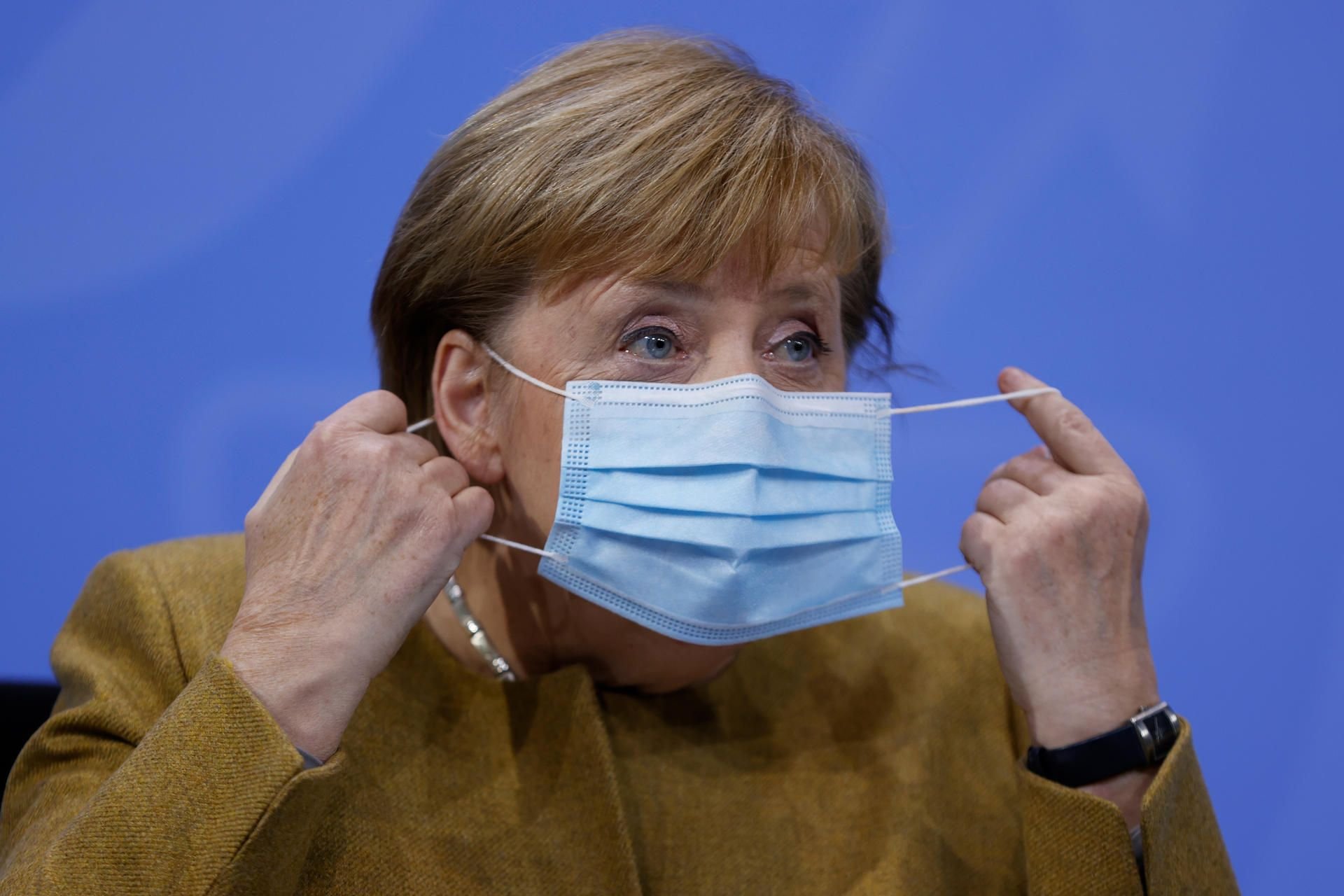 Bundeskanzlerin Angela Merkel (CDU) nimmt am Mittwoch vor ihrer Pressekonferenz ihre Gesichtsmaske ab.