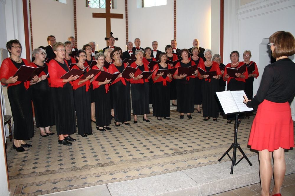 Sängerinnen und Sänger des Volkschores Muldeklang aus Jeßnitz mit ihrer Chorleiterin Bernadette Göthe (re.)