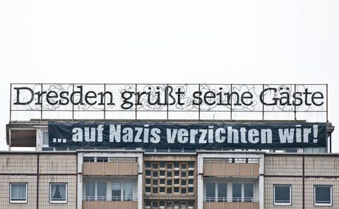 Unter dem alten Schriftzug «Dresden grüßt seine Gäste» hängt auf einem Hochhaus aus DDR-Zeiten am Postplatz in Dresden ein Banner mit den Worten «... auf Nazis verzichten wir!». (FOTO: DPA)