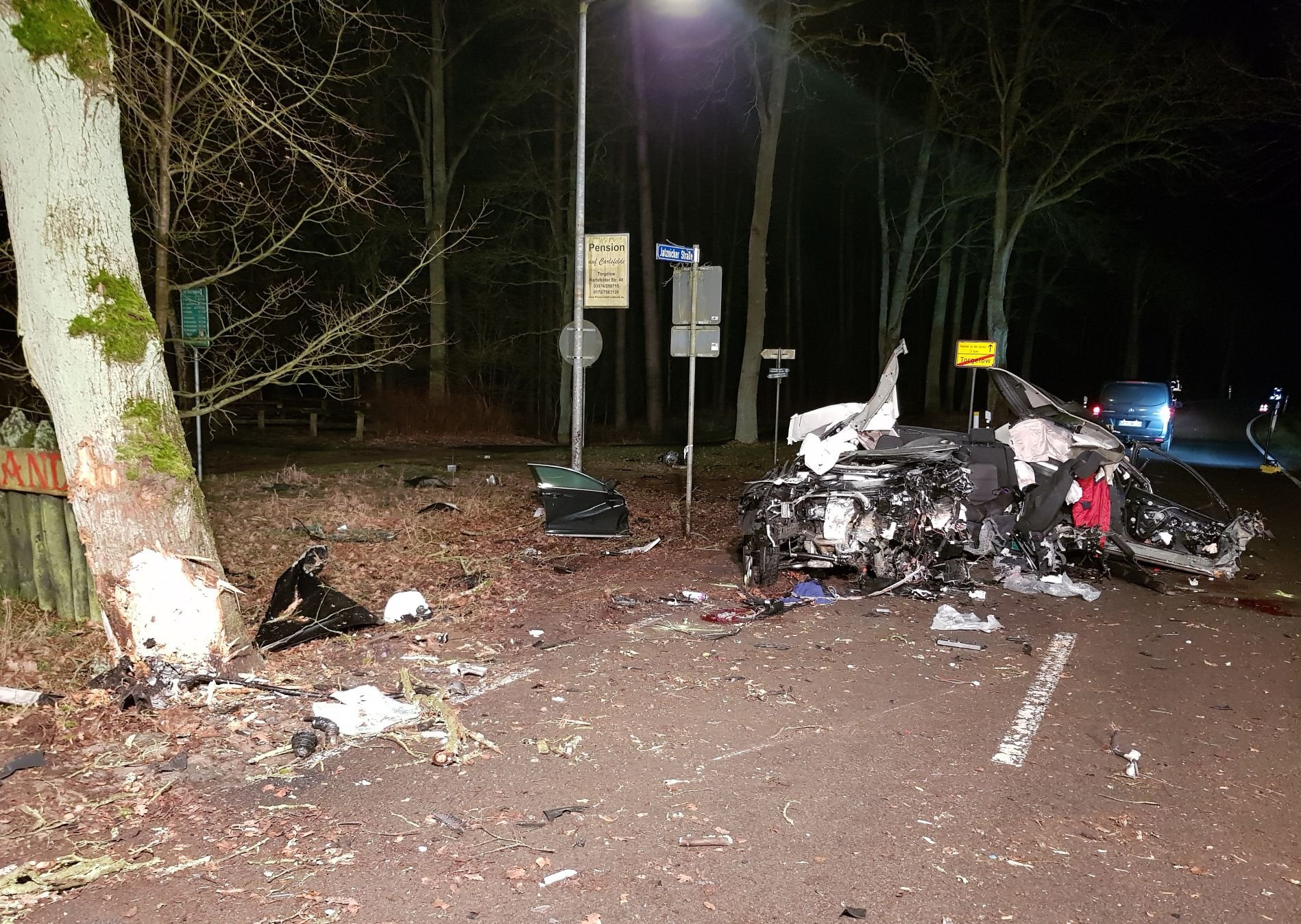 Ein völlig zerstörtes Fahrzeug steht nach einer Kollision mit einem Baum auf der Straße. Drei junge Männer sind bei dem schweren Verkehrsunfall ums Leben gekommen.