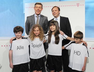 Christian Illek (l-r oben), Bereichsvorstand Marketing T-Home, und Rainer Hüther, stellvertretender Vorstandsvorsitzender der Constantin Medien AG,auf einer Pressekonferenz mit Kindern, die auf Shirts "Alle Spiele in HD" zu stehen haben. (FOTO: DPA)