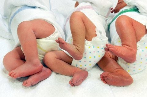 Drei Säuglinge liegen nebeneinander in einem Bettchen. (FOTO: DPA)