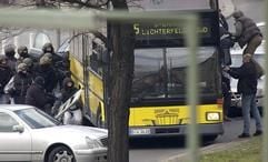 Einsatzkräfte eines Sondereinsatzkommandos der Polizei stürmen am Freitag (11.04.2003) in Berlin-Schöneberg einen Bus, mit dem ein Bankräuber mit Geiseln nach einem Bankraub geflüchtet ist. Der Geiselnehmer wurde vor dem Sturm (rechts). angeschossen. Foto: Andreas Altwein dpa/lbn