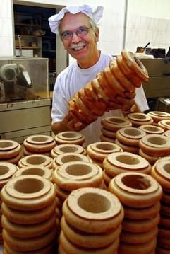 Der Baumkuchenbäcker Rolf-Dieter Friedrich hält in seiner Bäckerei in Wernigerode einen fertigen Baumkuchen in der Hand. Mit Zucker- oder Schokoladenüberzug werden die Kuchen weiter veredelt. (Foto: dpa)