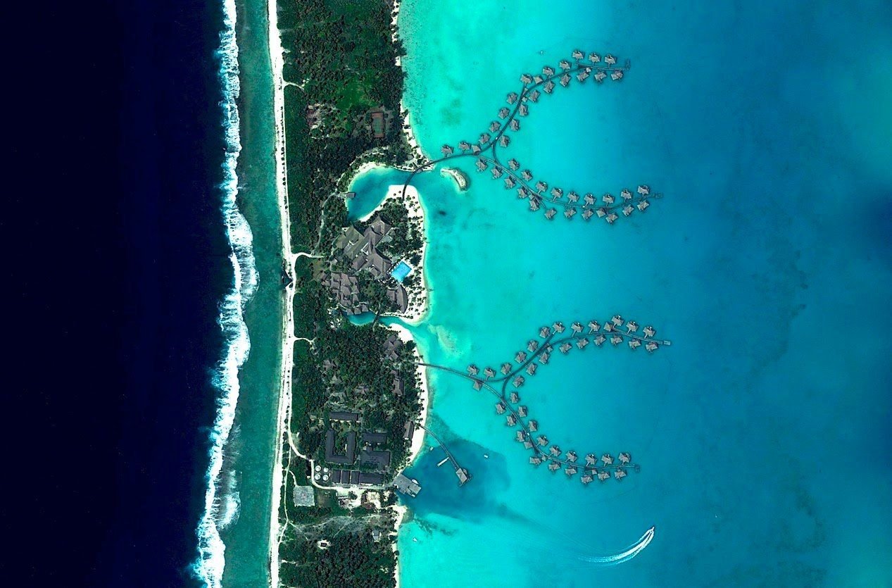 Blaue Stunde auf Bora Bora: Überwasser-Bungalows eines Luxus-Resorts in Französisch-Polynesien.