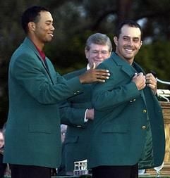Der Kanadier Mike Weir (r) erhält von Tiger Woods das grüne Jacket. (Foto: dpa)