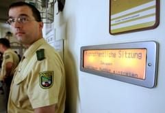Polizisten stehen am Mittwoch (10.05.2006) vor dem Gerichtssaal im Amtsgericht Schönebeck neben einem Schild, das auf die Nichtöffentlichkeit des Prozesses hinweist. (Foto: dpa)
