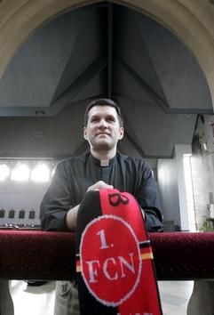 Der katholische Priester Stefan Menz betet am Donnerstag (17.03.2005) in der Kirche in Baunach bei Bamberg. Im Abstiegskampf der Fußball-Bundesliga setzt der 1. FC Nürnberg auf göttliche Hilfe. Er sehe es als seine Aufgabe an, für alle Cluberer zu beten. Für die Mannschaft und für die Fans, meint der 32-jährige «Club-Kaplan», der seine ehrenamtliche Tätigkeit aber nicht als «göttliche Magie» verstanden wissen will. (Foto: dpa)
