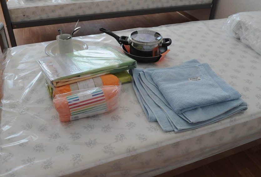 Auf jedem Bett lagen unter anderem Bettwäsche, Handtücher, ein Pfannen- und Topfset und Geschirr.