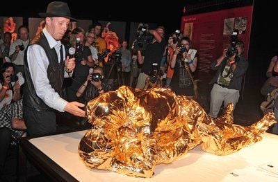 Leichen-Präparator Gunther von Hagens steht in Augsburg (Bayern) neben plastinierten Leichen unter einer Goldfolie, die beim Geschlechtsverkehr gezeigt werden. Die Stadt Augsburg hat verboten, das Objekt bei der Ausstellung «Körperwelten - Eine Herzensangelegenheit» zu präsentieren. (FOTO: DPA)