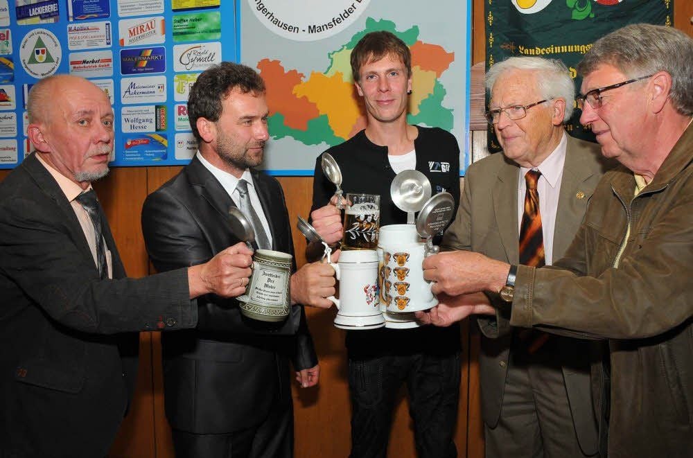 Innungsobermeister Frank Grünewald (links) lud den besten Lehrling des Jahrgangs, Peter Heine (Mitte), zum Anstoßen mit den historischen Bierkrügen ein.