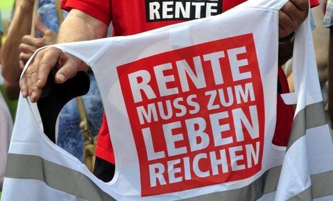 Rentner demonstriert vor dem Reichstag in Berlin und hält dabei eine Weste in den Händen, auf der «Rente muss zum Leben reichen» zu lesen ist. (FOTO: DPA)