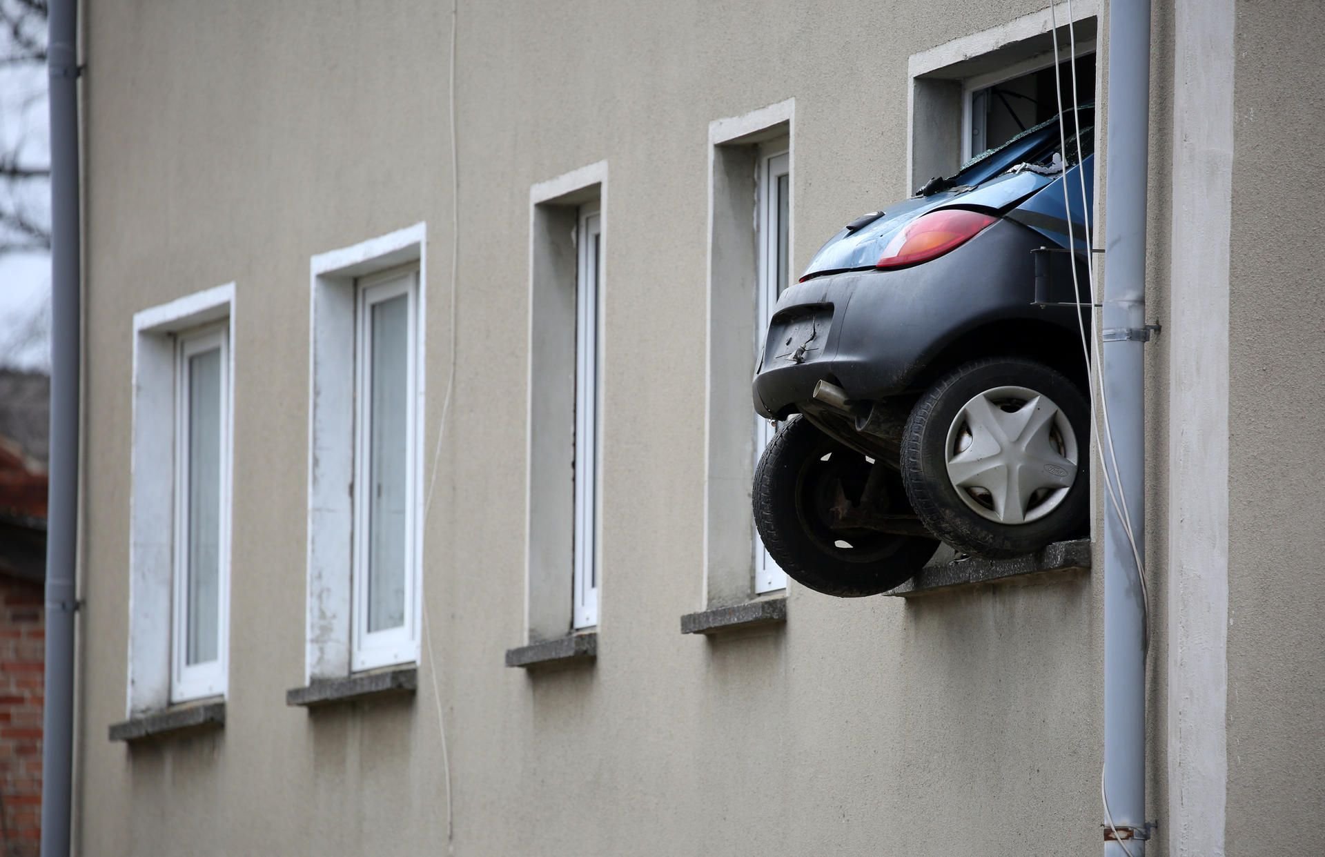 Komischer Anblick: Ein Ford Ka ragt zum Teil aus dem Fenster eines Mehrfamilienhauses.