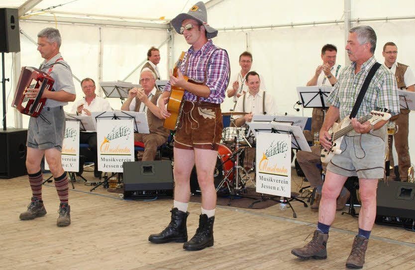 Arnsdorfs Randfichten, Maik Höhne, Christian Räbiger, Gerd Kitzhofer, in Aktion. Dahinter die Elbaue-Musikanten, die zum Dorffest traditionell spielen.