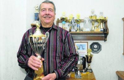 Heinz Hille präsentiert 2012 den MZ-Pokal. Erflogen haben ihn seine Täubchen. Wie auch die vielen anderen auf dem Regal im Hintergrund.