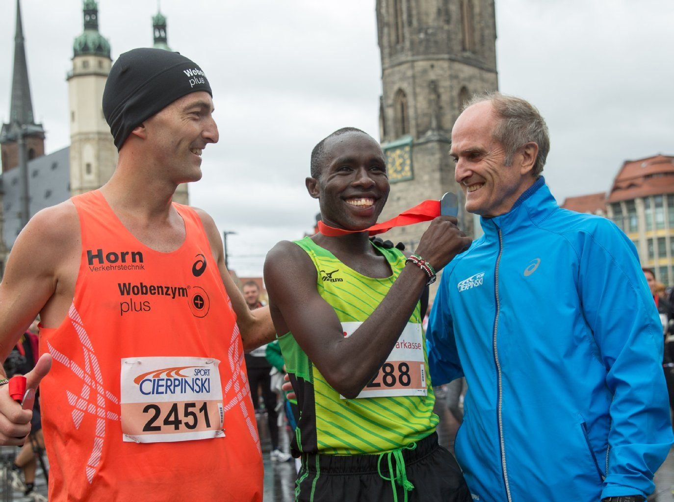 Waldemar Cierpinski (r.) und dessen Sohn Falk, der den Halbmarathon gewann, freuen sich mit dem Kenianer Dickson Kurui (M.) als Sieger des 14. Mitteldeutschen Marathon auf dem Markt in Halle.