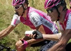 Rolf Aldag (r) übergibt seinem Teamkollegen Jan Ullrich eine Trinkflasche. (Foto: dpa)