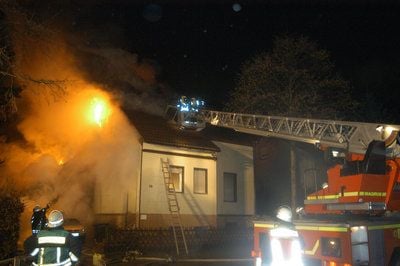 Feuerwehrleute löschen ein in Flammen stehendes Zweifamilienhaus am Freitag im westfälischen Unna. (FOTO: DPA)